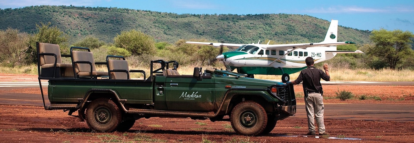 Safari jeep and and parked aeroplane