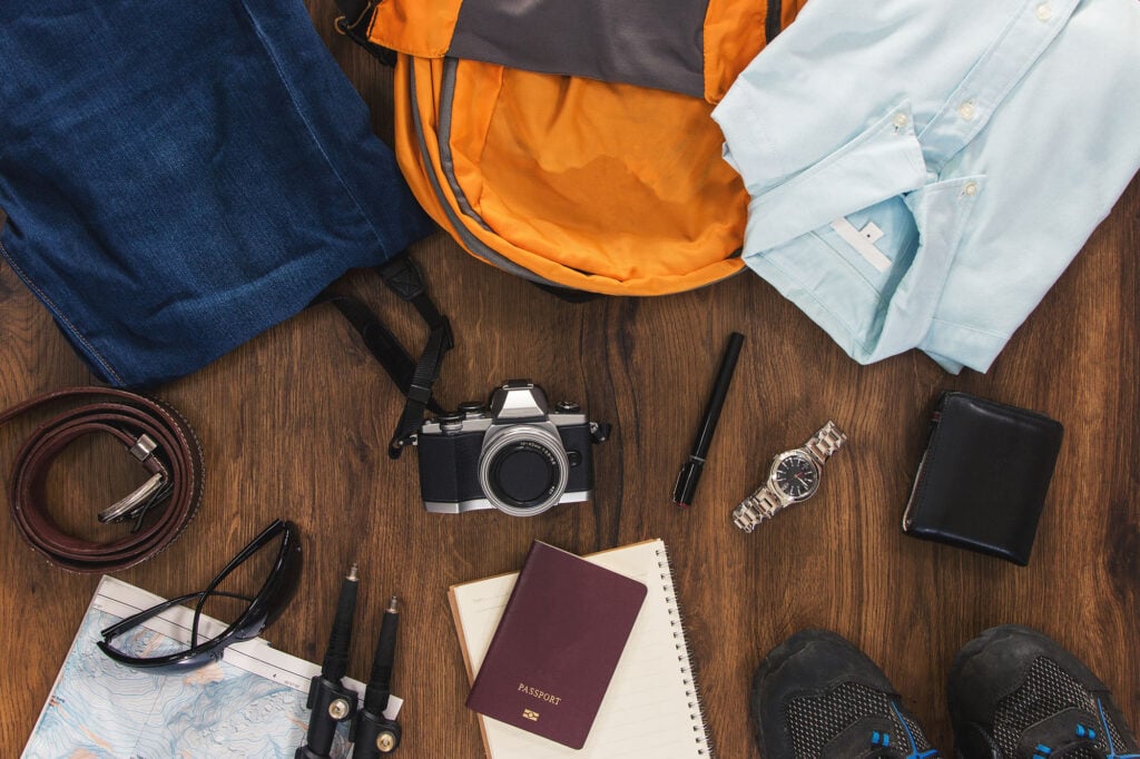 Top view of trekking travel stuff, clothing and backpack